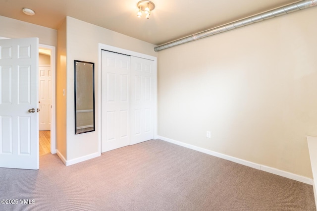 unfurnished bedroom with a closet, baseboards, and carpet