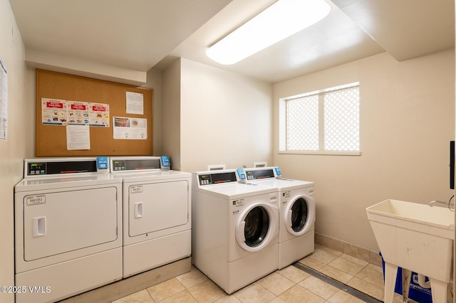 common laundry area with light tile patterned floors, baseboards, and independent washer and dryer