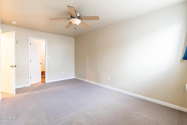 carpeted spare room with baseboards and a ceiling fan