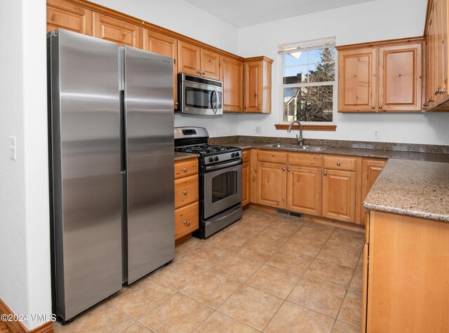 49 Bluffs Dr, Eagle, CO 81631 - kitchen featuring dark stone countertops, appliances with stainless steel finishes, sink, and light tile patterned floors