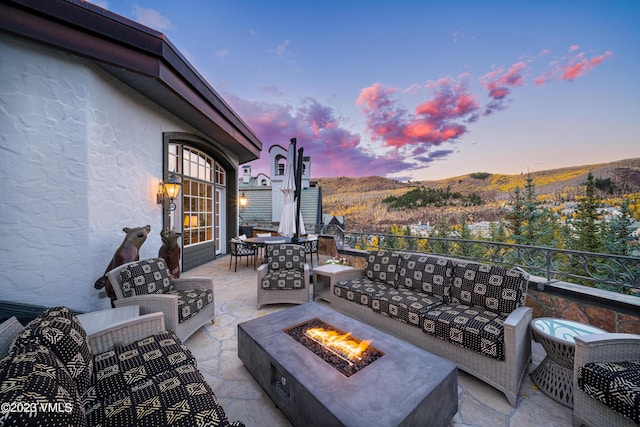 17 Chateau Ln Unit 501, Beaver Creek, CO 81620 - patio terrace at dusk featuring an outdoor living space with a fire pit, a patio, a mountain view, and outdoor dining area