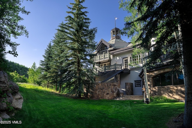 17 Chateau Ln Unit 501, Beaver Creek, CO 81620 - rear view of house with stucco siding, stone siding, and a yard