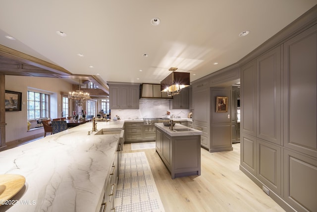 17 Chateau Ln Unit 501, Beaver Creek, CO 81620 - kitchen featuring a chandelier, wall chimney range hood, light wood finished floors, pendant lighting, and recessed lighting