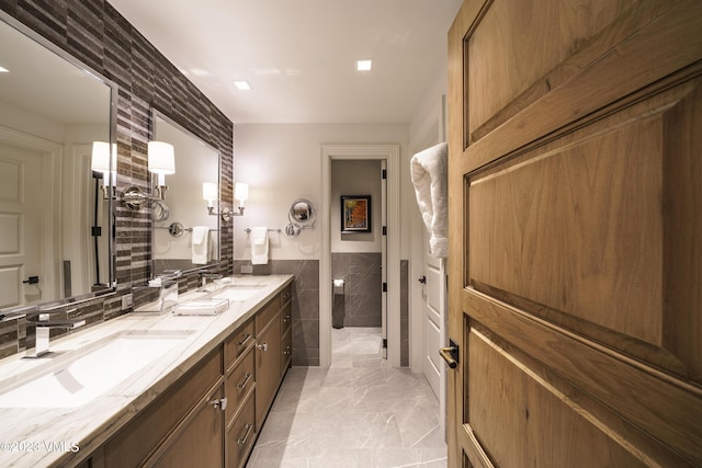 17 Chateau Ln Unit 501, Beaver Creek, CO 81620 - full bath with double vanity, tile walls, marble finish floors, and a wainscoted wall