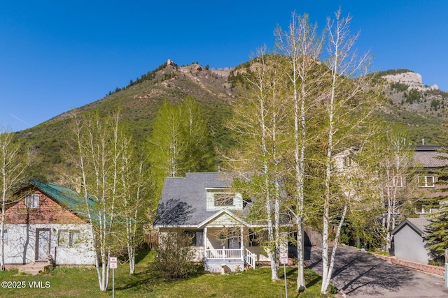 562 Main St, Minturn, CO 81645 - view of front of home with a porch, a mountain view, a front lawn, and driveway