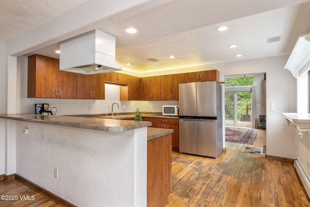 562 Main St, Minturn, CO 81645 - kitchen featuring freestanding refrigerator, white microwave, a peninsula, brown cabinets, and recessed lighting