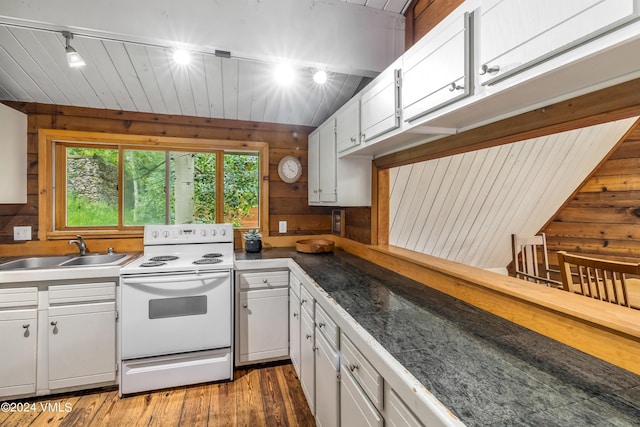 kitchen featuring sink, white cabinets, wooden walls, and electric stove