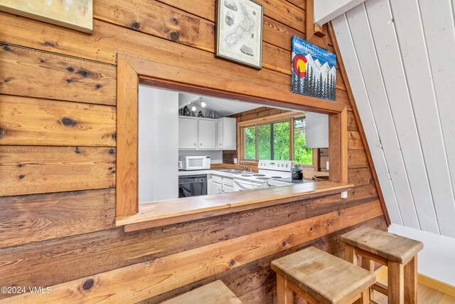 2963 Bellflower Dr, Vail, CO 81657 - kitchen featuring white appliances, wooden walls, sink, and white cabinets