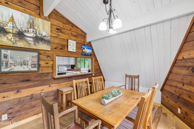 dining area with wooden walls, lofted ceiling, a chandelier, wood ceiling, and light hardwood / wood-style flooring