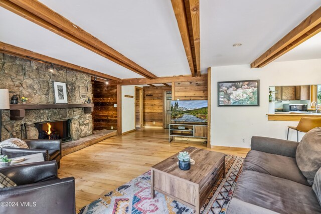 living room with hardwood / wood-style flooring, a fireplace, and beam ceiling