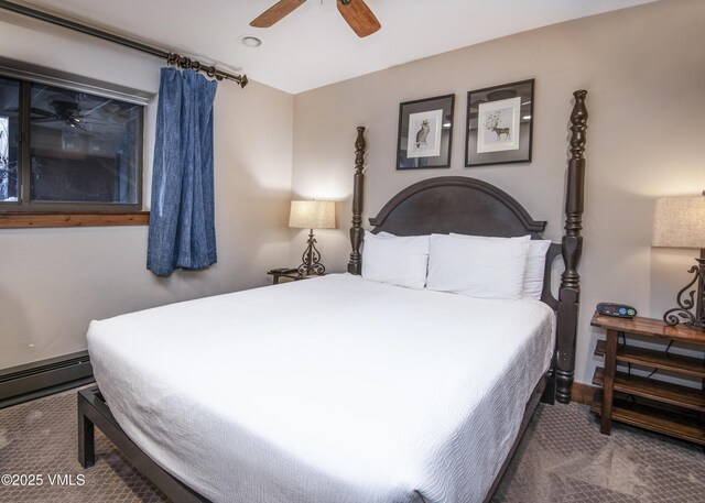 carpeted bedroom featuring a baseboard heating unit and a ceiling fan