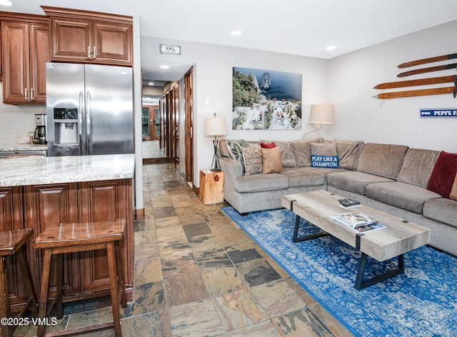 living area with recessed lighting and stone finish flooring