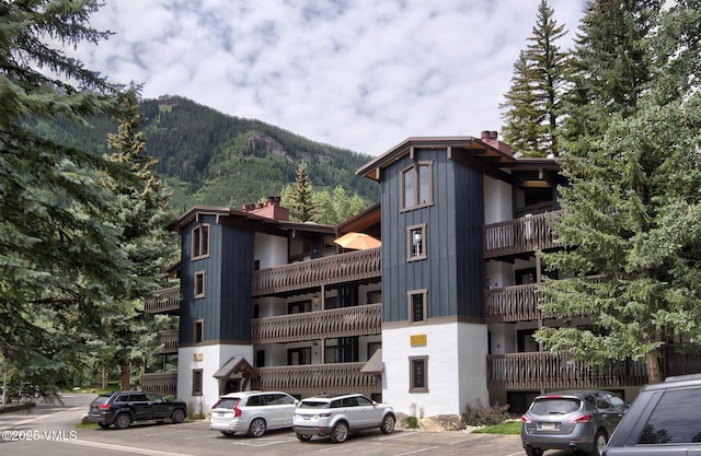 view of property with a mountain view and uncovered parking