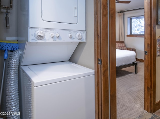 laundry room with carpet flooring, laundry area, and stacked washer / dryer