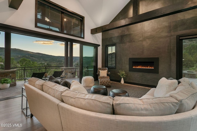 420 Little Andorra Rd, Edwards, CO 81632 - living area featuring wood finished floors, high vaulted ceiling, a tile fireplace, and a mountain view