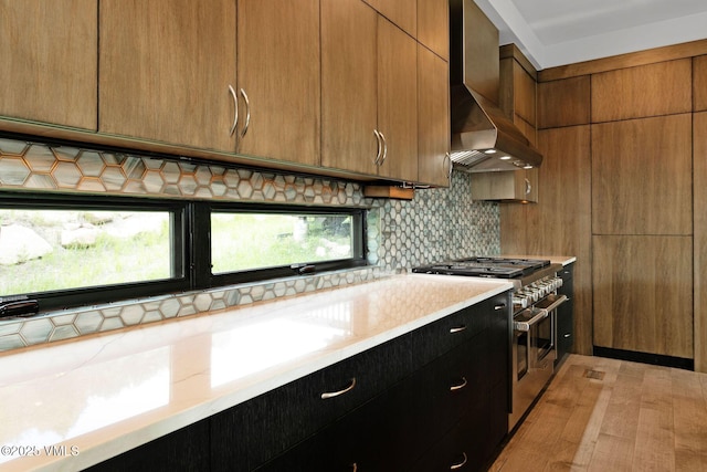 420 Little Andorra Rd, Edwards, CO 81632 - kitchen featuring wall chimney range hood, double oven range, tasteful backsplash, brown cabinetry, and dark cabinetry