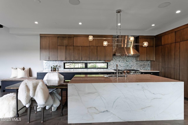 420 Little Andorra Rd, Edwards, CO 81632 - kitchen with wall chimney exhaust hood, decorative backsplash, modern cabinets, recessed lighting, and a kitchen island with sink