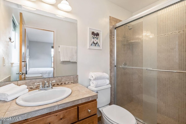 bathroom featuring an enclosed shower, vanity, and toilet