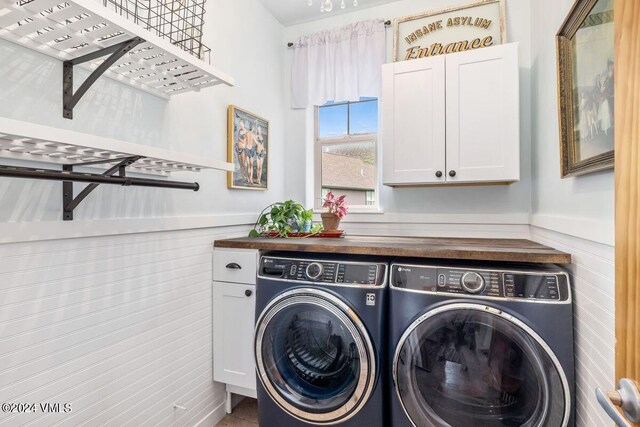 clothes washing area with cabinets and independent washer and dryer