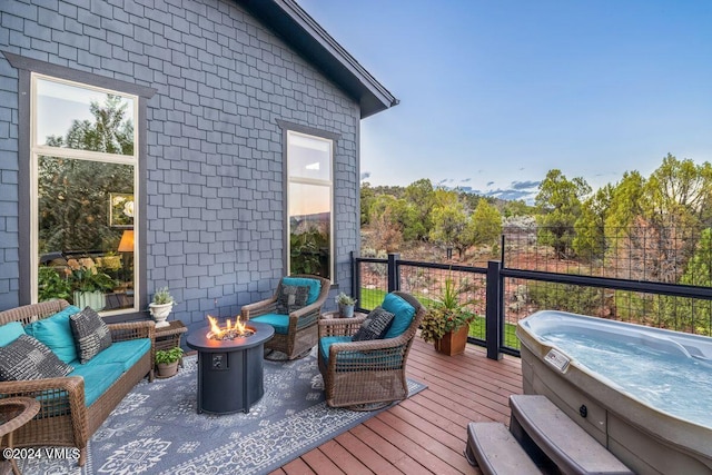 deck featuring an outdoor hot tub and an outdoor living space with a fire pit