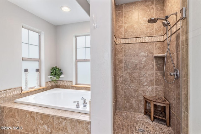 bathroom featuring independent shower and bath and a healthy amount of sunlight