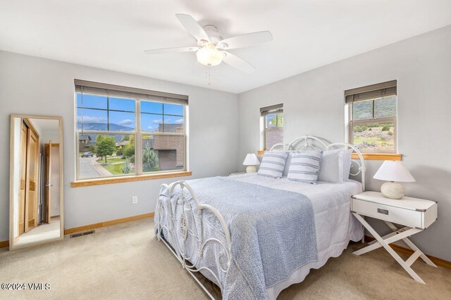 carpeted bedroom featuring ceiling fan and a mountain view