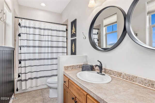 bathroom with tile patterned flooring, vanity, and toilet