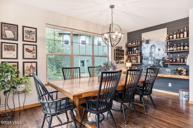 dining area featuring indoor bar, dark wood-type flooring, and a notable chandelier