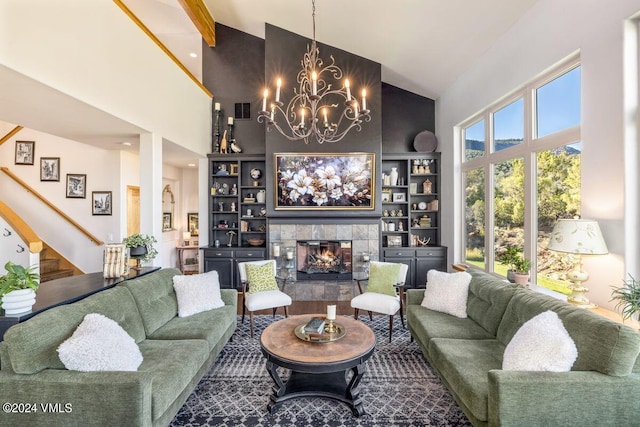 living room with built in shelves, a tiled fireplace, and high vaulted ceiling