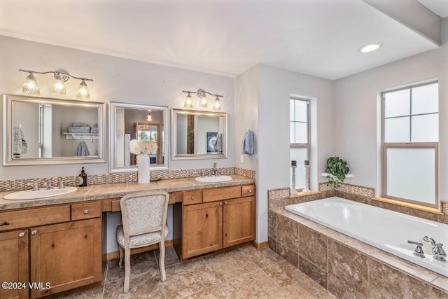 bathroom with vanity, tile patterned flooring, and tiled bath