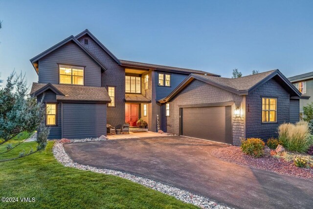 craftsman-style home featuring a garage and a yard