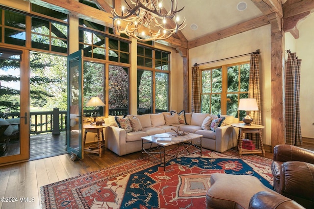 sunroom featuring a notable chandelier and beam ceiling