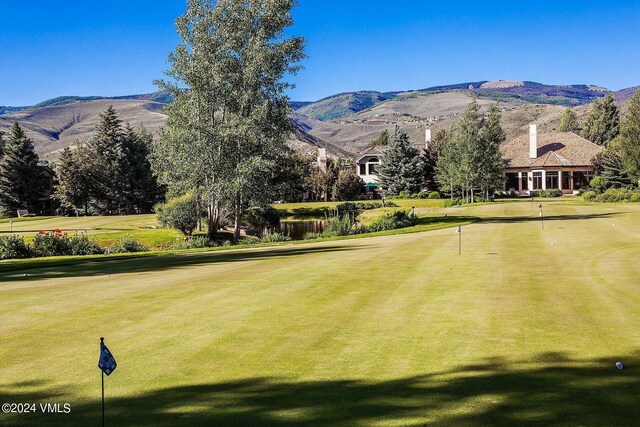 view of property's community with a mountain view and a yard