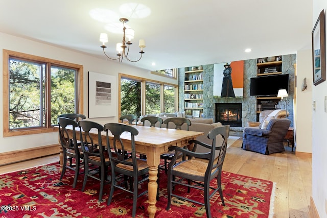 2111 Vermont Rd Unit A, Vail, CO 81657 - dining space featuring a fireplace, a chandelier, light wood-style flooring, built in features, and recessed lighting