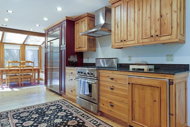 2111 Vermont Rd Unit A, Vail, CO 81657 - kitchen with wall chimney exhaust hood, premium appliances, recessed lighting, light wood-style floors, and dark stone countertops