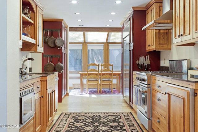 2111 Vermont Rd Unit A, Vail, CO 81657 - kitchen featuring wall chimney range hood, appliances with stainless steel finishes, recessed lighting, light wood-style floors, and dark stone counters