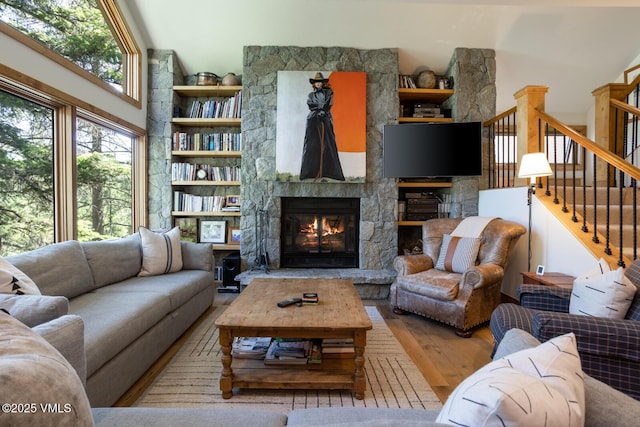 2111 Vermont Rd Unit A, Vail, CO 81657 - living room featuring wood finished floors, a stone fireplace, and stairway