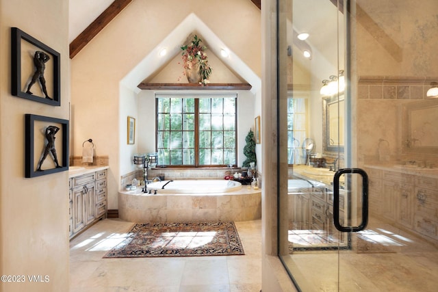 bathroom with vanity, a relaxing tiled tub, and high vaulted ceiling