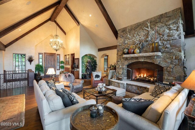 living room with beam ceiling, high vaulted ceiling, a notable chandelier, a fireplace, and wood-type flooring