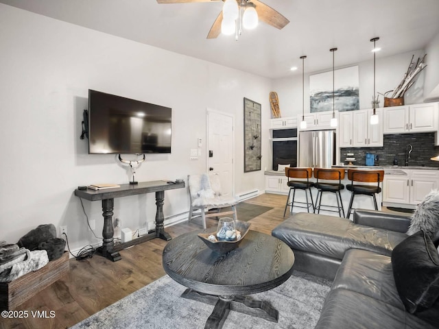 1061 W Beaver Creek Blvd Unit F-203, Avon, CO 81620 - living area featuring light wood finished floors, ceiling fan, a baseboard radiator, recessed lighting, and baseboards
