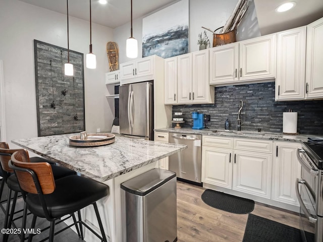 1061 W Beaver Creek Blvd Unit F-203, Avon, CO 81620 - kitchen with stainless steel appliances, a sink, decorative backsplash, light stone countertops, and light wood-style flooring