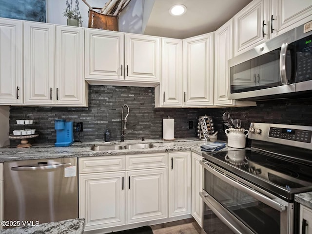 1061 W Beaver Creek Blvd Unit F-203, Avon, CO 81620 - kitchen with stainless steel appliances, a sink, tasteful backsplash, and white cabinets