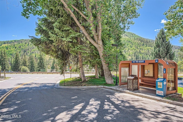 1023 Lions Ridge Loop Unit 111, Vail, CO 81657 - view of asphalt road featuring a forest view, curbs, and a mountain view
