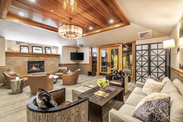 684 W Lionshead Cir Unit 302, Vail, CO 81657 - carpeted living room with french doors, wood ceiling, a stone fireplace, a chandelier, and a raised ceiling