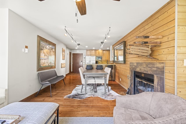 1100 N Frontage Rd W Unit 2504, Vail, CO 81657 - living room with track lighting, a ceiling fan, wood finished floors, a tiled fireplace, and wooden walls