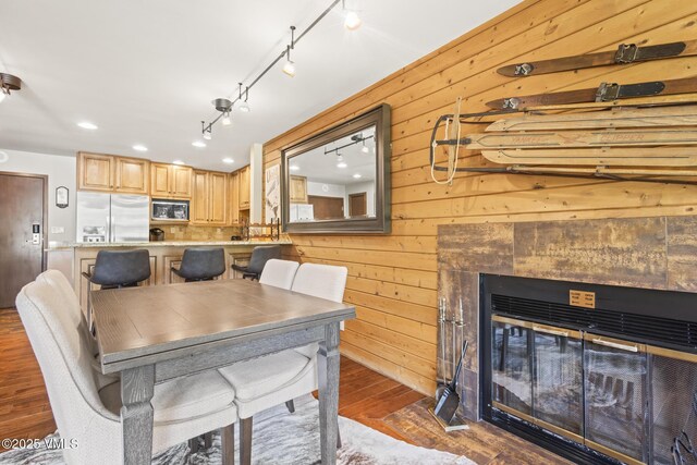 1100 N Frontage Rd W Unit 2504, Vail, CO 81657 - dining room featuring wood finished floors, wooden walls, a fireplace, track lighting, and recessed lighting