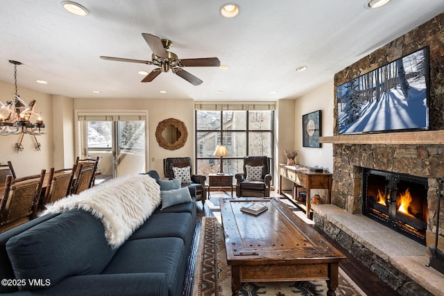 living area featuring recessed lighting, a fireplace, and ceiling fan with notable chandelier