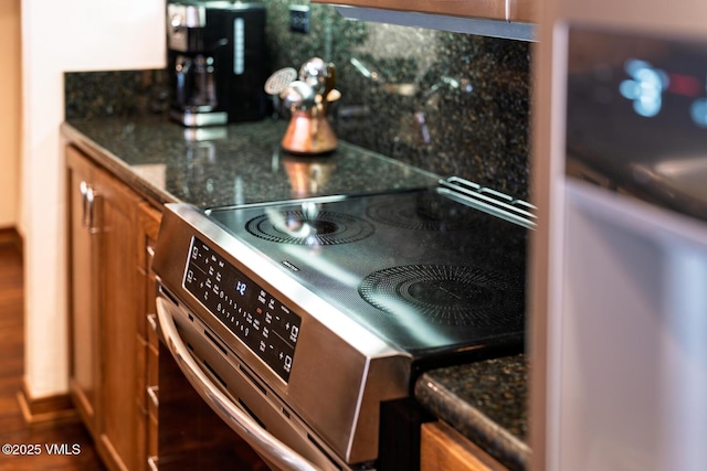 details featuring brown cabinetry, stainless steel electric range, and dark countertops