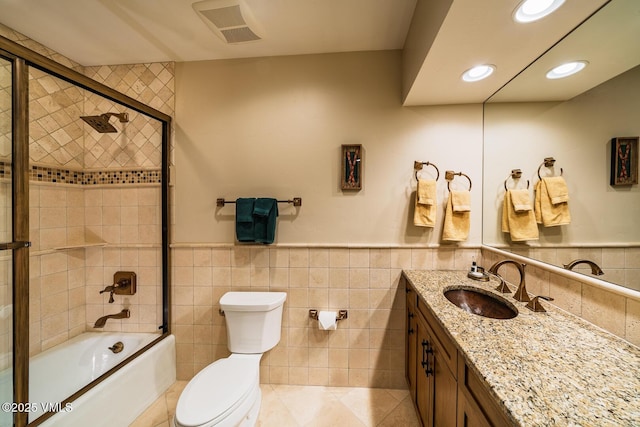 full bathroom featuring visible vents, enclosed tub / shower combo, recessed lighting, tile walls, and toilet