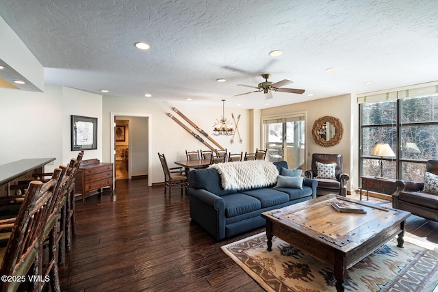 living area with recessed lighting, a textured ceiling, dark wood-style floors, and ceiling fan with notable chandelier